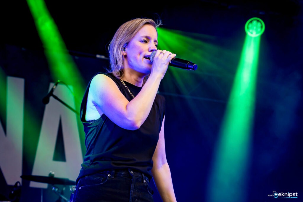 Sängerin bei einem Konzert mit grünem Licht.