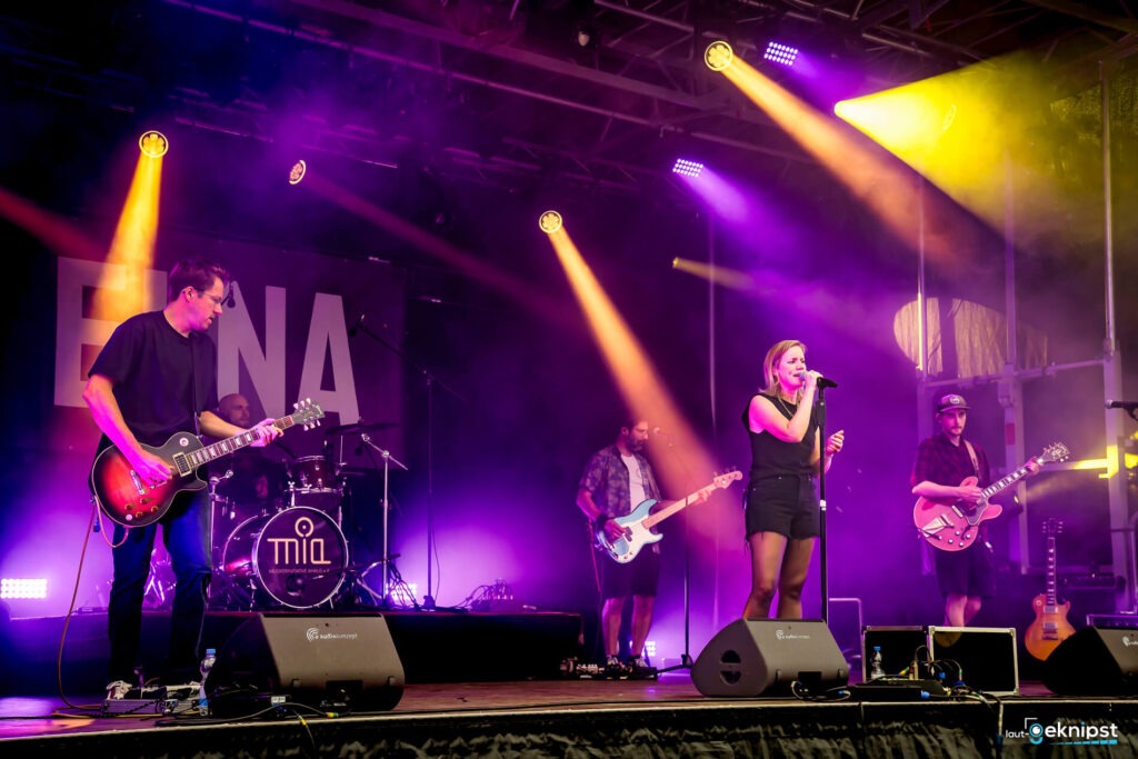 Band spielt auf beleuchteter Bühne live Musik