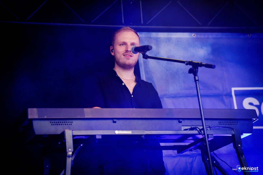Person spielt Keyboard auf der Bühne.