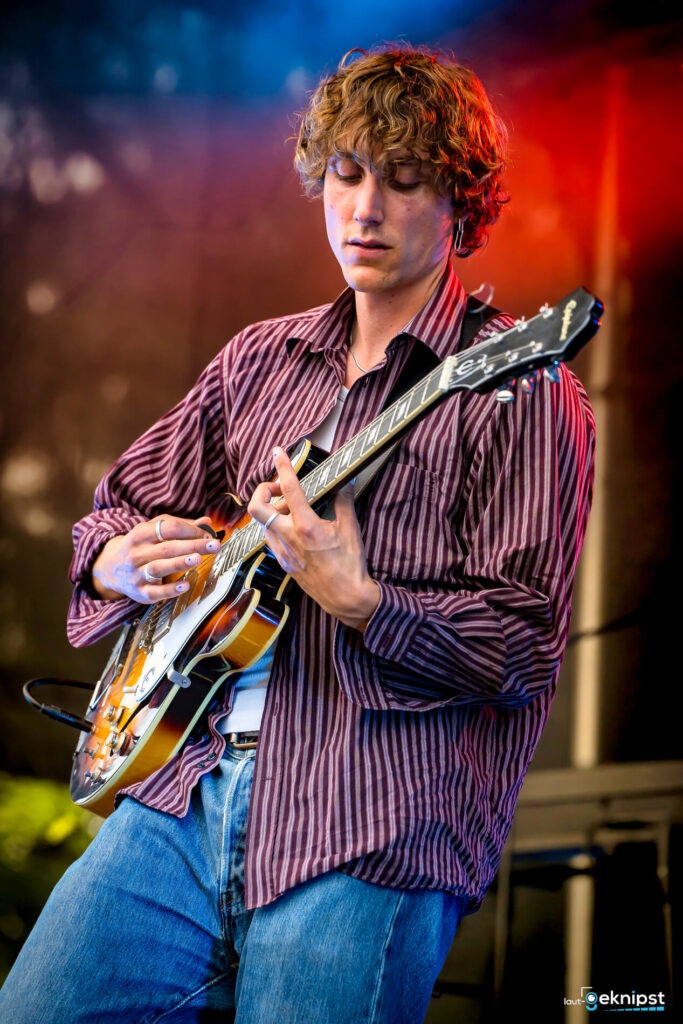 Mann spielt E-Gitarre bei Konzert