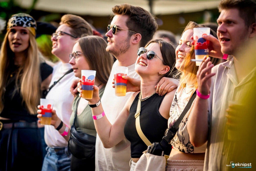Gruppe feiert mit Getränken auf einem Festival
