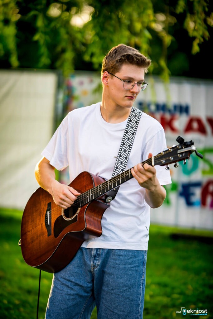 Mann spielt Gitarre im Freien