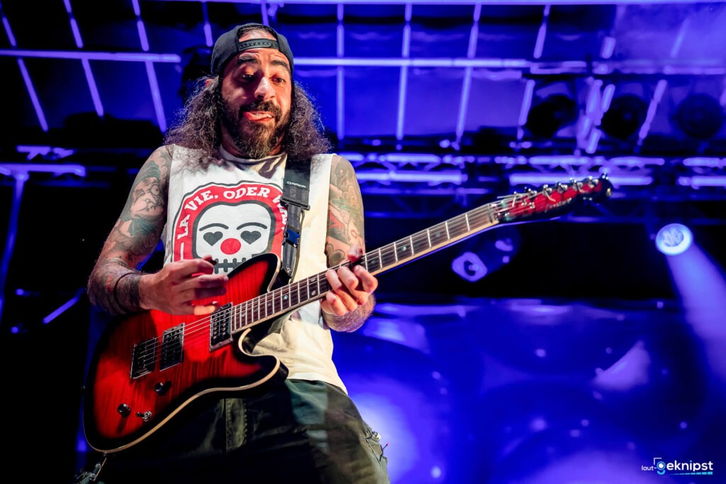 Gitarrist spielt auf Bühne mit roter E-Gitarre