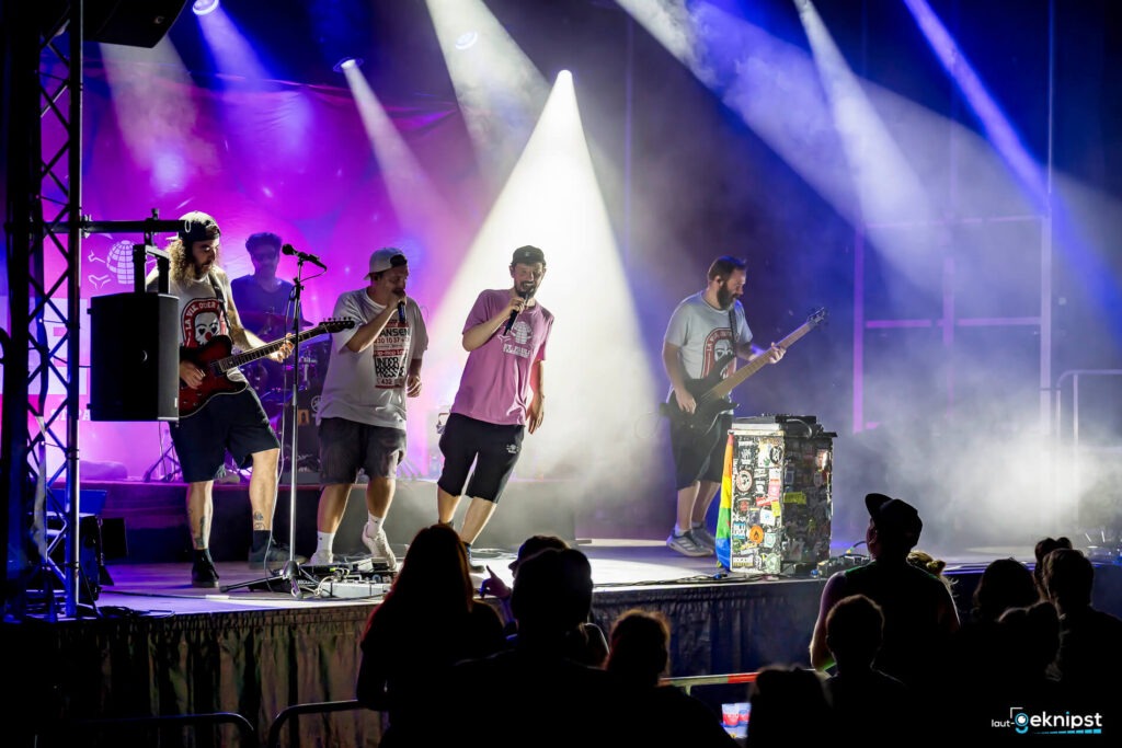 Band spielt auf einer Bühne vor Publikum.