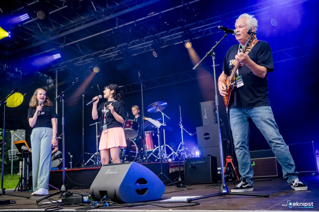Band spielt auf Außenbühne mit Instrumenten und Gesang