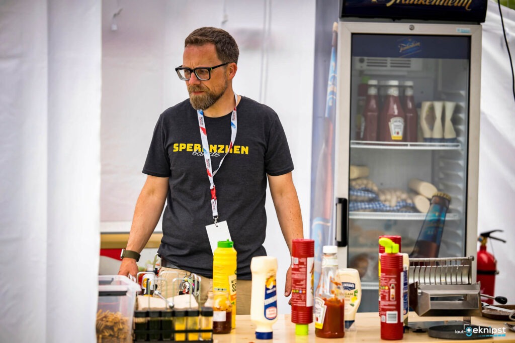 Mann am Stand mit Gewürzen und Kühlschrank