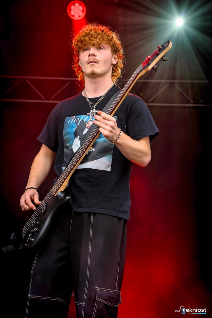 Musiker spielt Bassgitarre auf der Bühne.