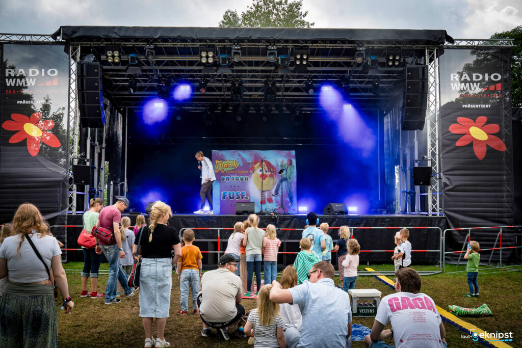 Freiluftkonzert für Kinder, Bühne und Publikum im Vordergrund.