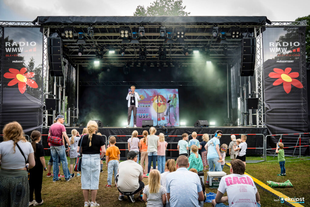 Kinderkonzert auf Open-Air-Bühne mit Moderator.