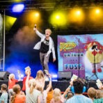 Mann singt auf Bühne, Kinder jubeln.