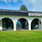 Museum mit gewölbtem Eingang und Rasen.