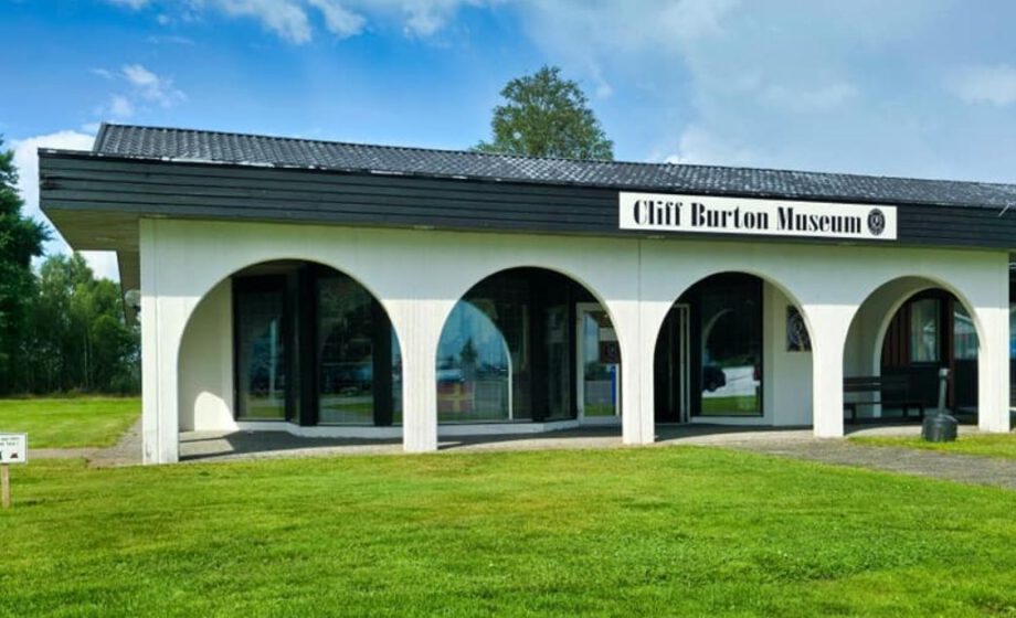 Museum mit gewölbtem Eingang und Rasen.