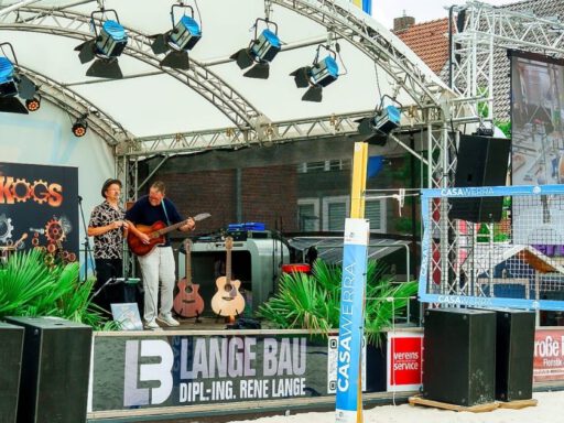 Live-Musik auf einer Außenbühne mit Leinwand.