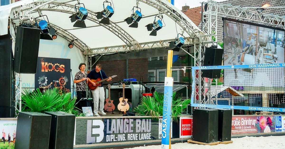 Live-Musik auf einer Außenbühne mit Leinwand.