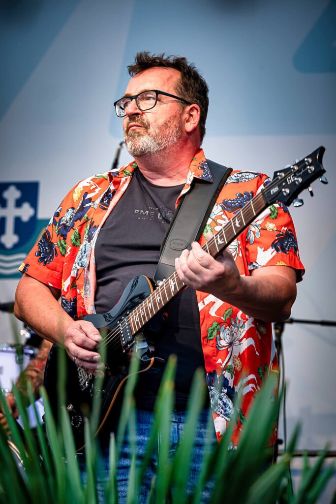 Mann spielt Gitarre auf der Bühne.