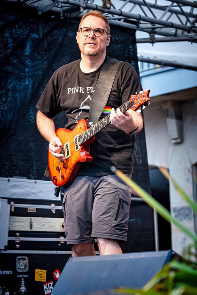 Mann mit E-Gitarre auf Bühne