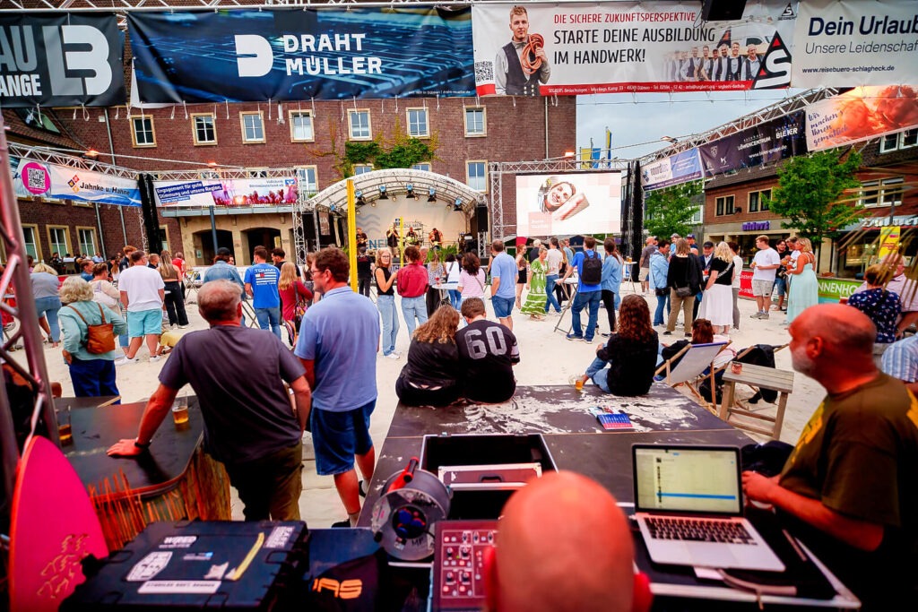 Menschen auf einem Outdoor-Event vor Bühne.