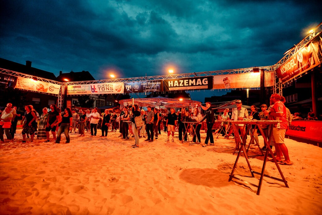 Menschen auf Sandfläche bei Nachtveranstaltung