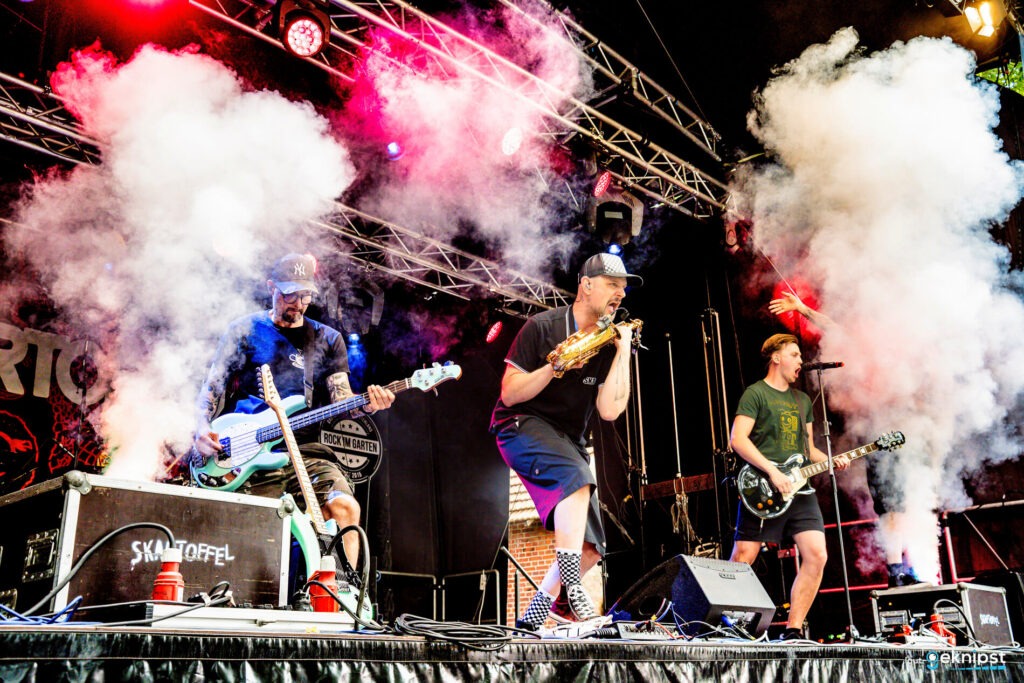 Band spielt auf einer Bühne mit Lichteffekten.