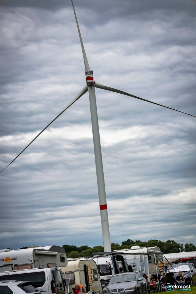 Windrad über Wohnmobilen am Himmel