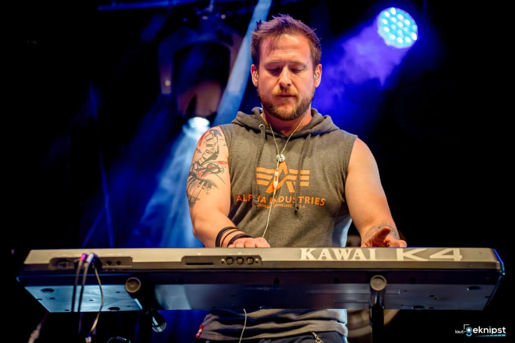 Musiker spielt Keyboard auf der Bühne.