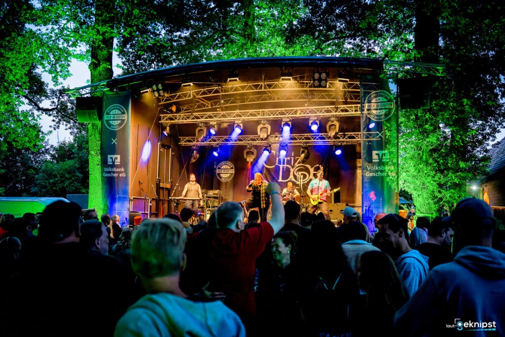Konzert im Freien mit Menschenmenge und Band.