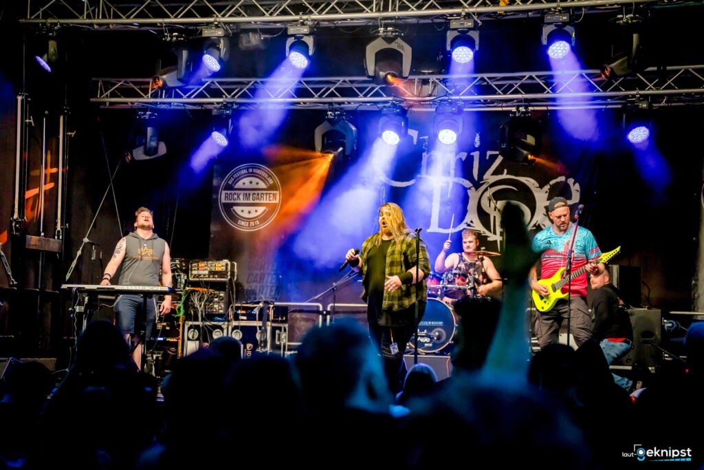 Band spielt Live-Konzert auf Festivalbühne mit Lichteffekten.