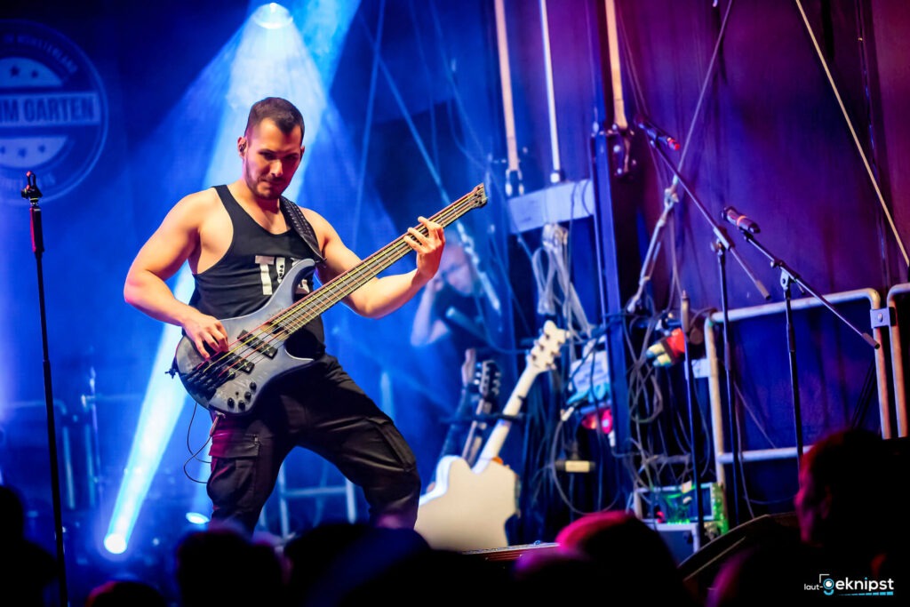 Bassgitarrist spielt auf Bühne bei Konzert