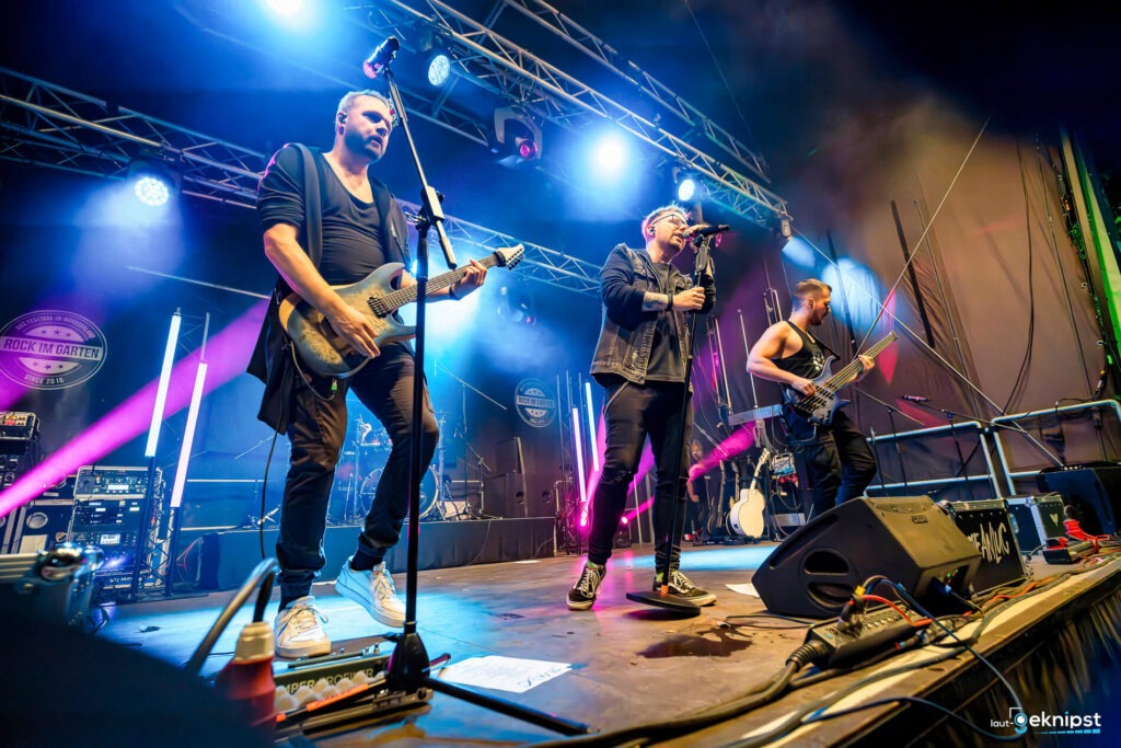 Band spielt auf Festivalbühne mit Lichteffekten.