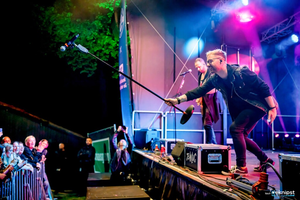 Musiker auf Bühne bei Live-Konzert mit Mikrofon