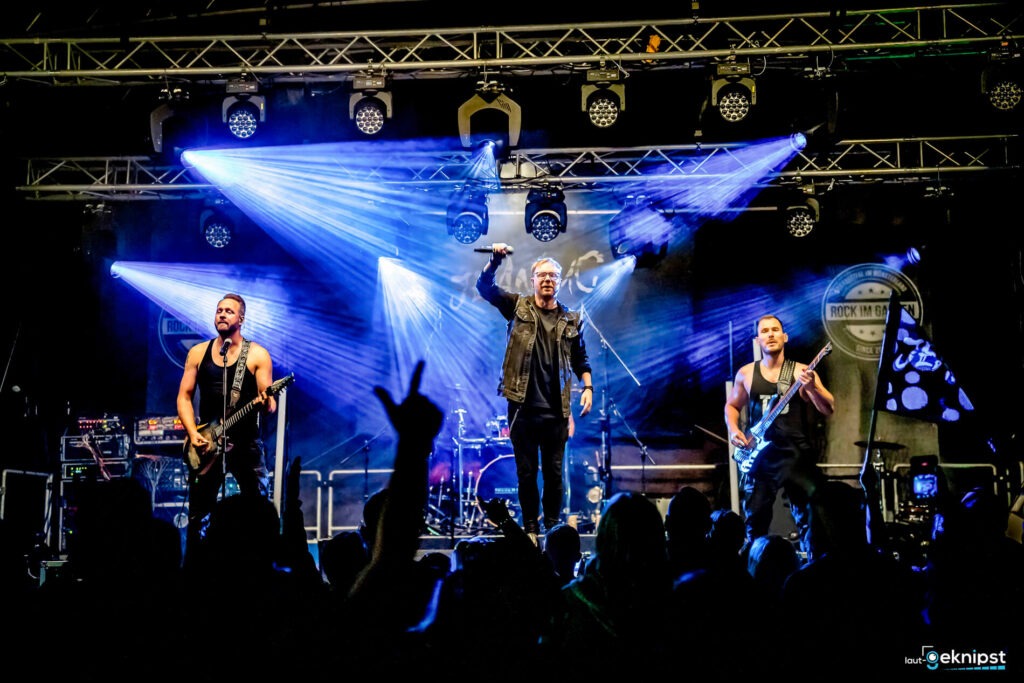 Band spielt auf Bühne mit Lichteffekten.