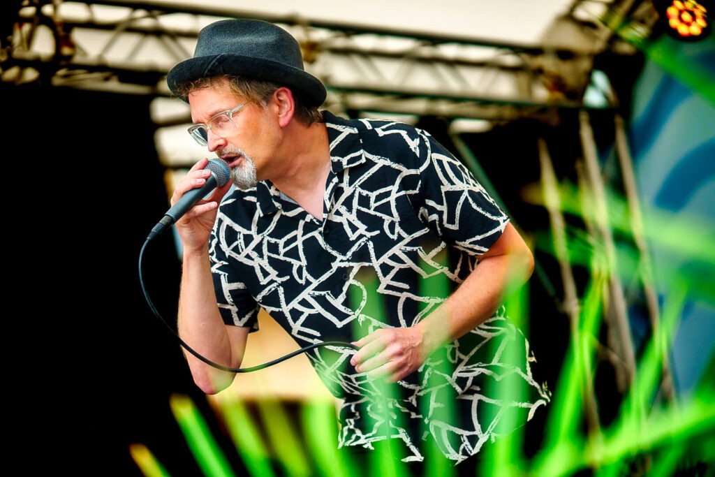 Mann singt auf Bühne mit Mikrofon