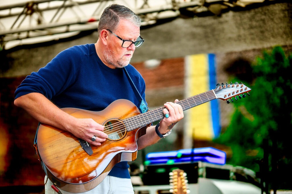 Mann spielt akustische Gitarre auf der Bühne