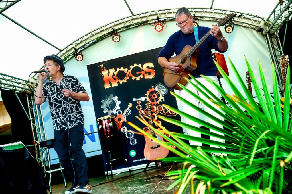 Bandperformanz auf der Bühne mit Pflanzen im Vordergrund