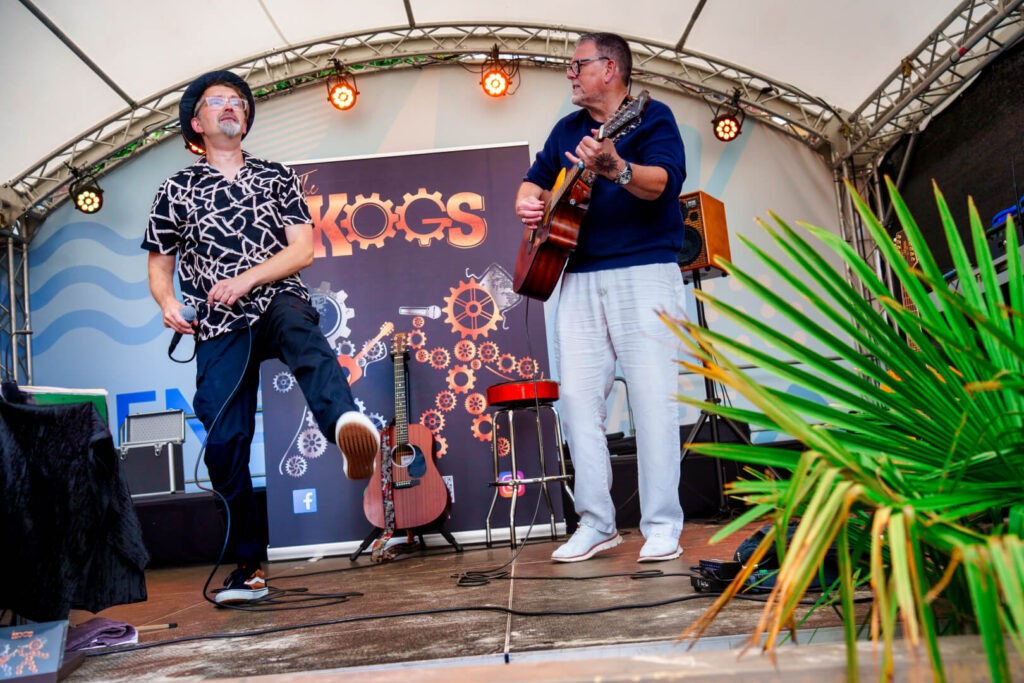 Zwei Musiker auf einer Bühne mit Instrumenten.