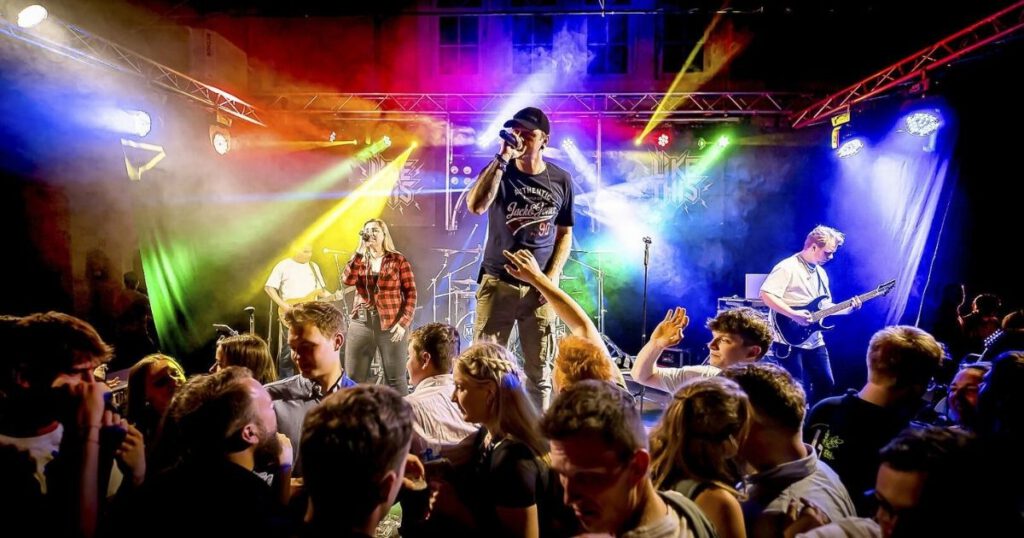 Band spielt Live-Konzert vor tanzendem Publikum.