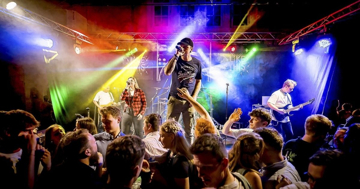 Band spielt Live-Konzert vor tanzendem Publikum.