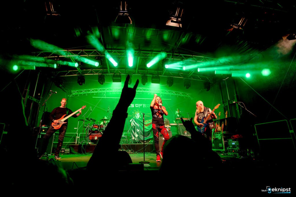 Live-Rockkonzert auf Bühne mit grüner Beleuchtung