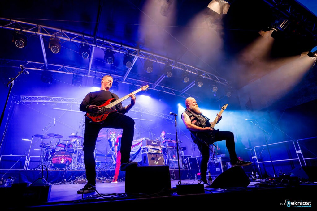Rockband spielt auf einer Bühne mit Beleuchtung.