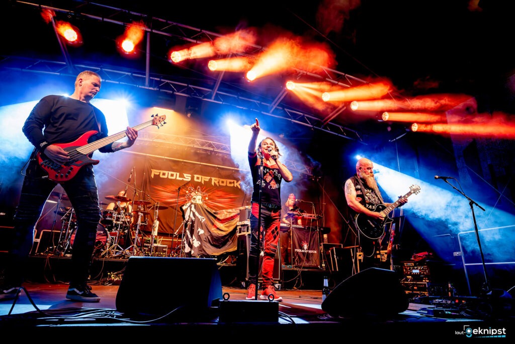 Rockband performt auf Bühne mit Lichtshow.