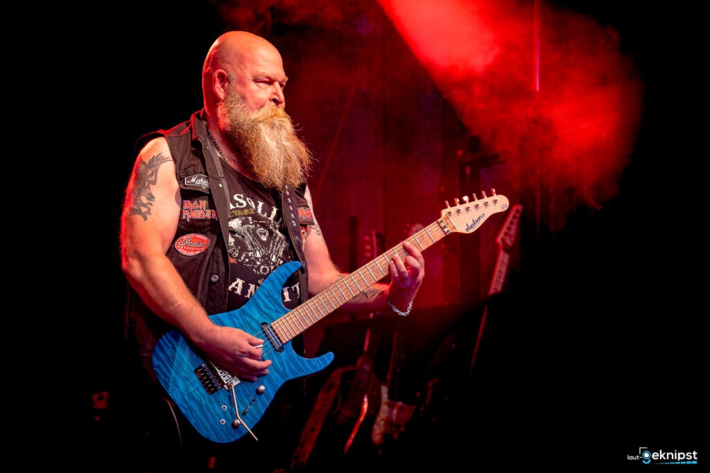 Gitarrist mit blauer E-Gitarre auf der Bühne