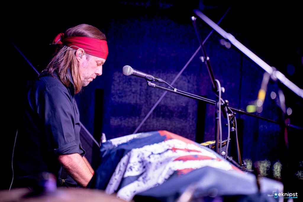 Musiker am Keyboard mit rotem Stirnband