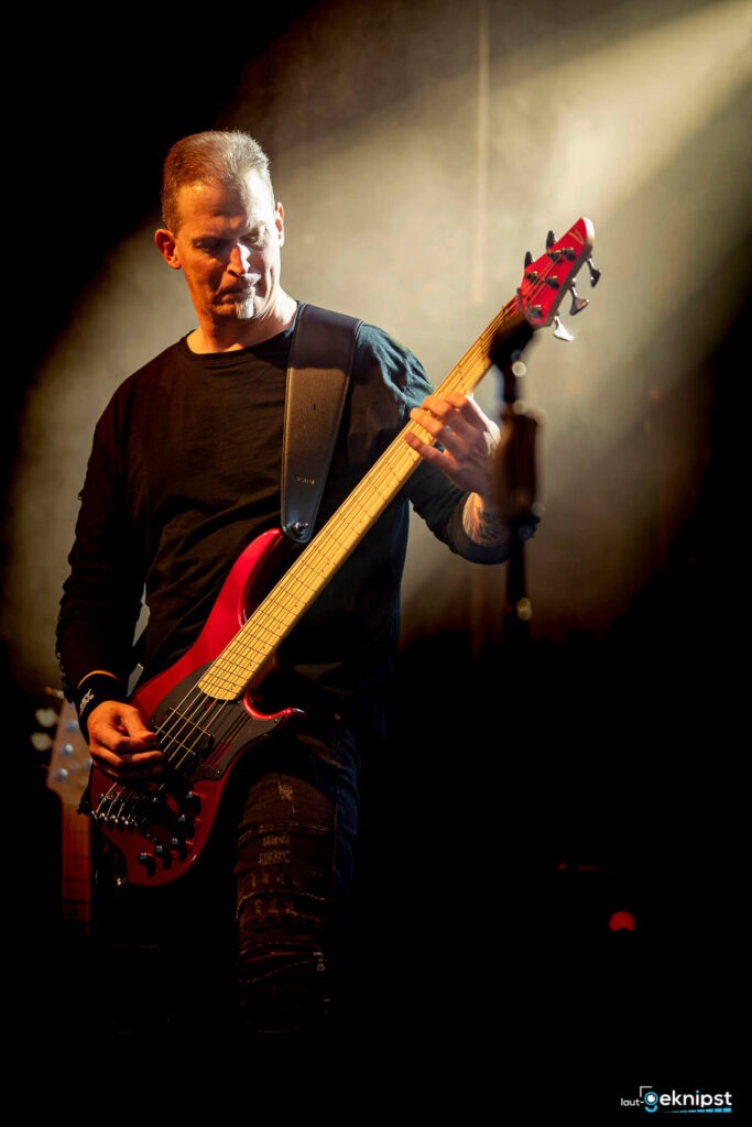 Musiker spielt roten Bass auf der Bühne.