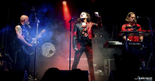 Band spielt Live-Konzert auf Bühne mit Lichteffekten.