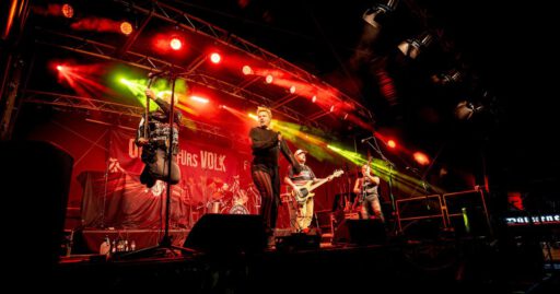 Band bei einem Konzert auf beleuchteter Bühne