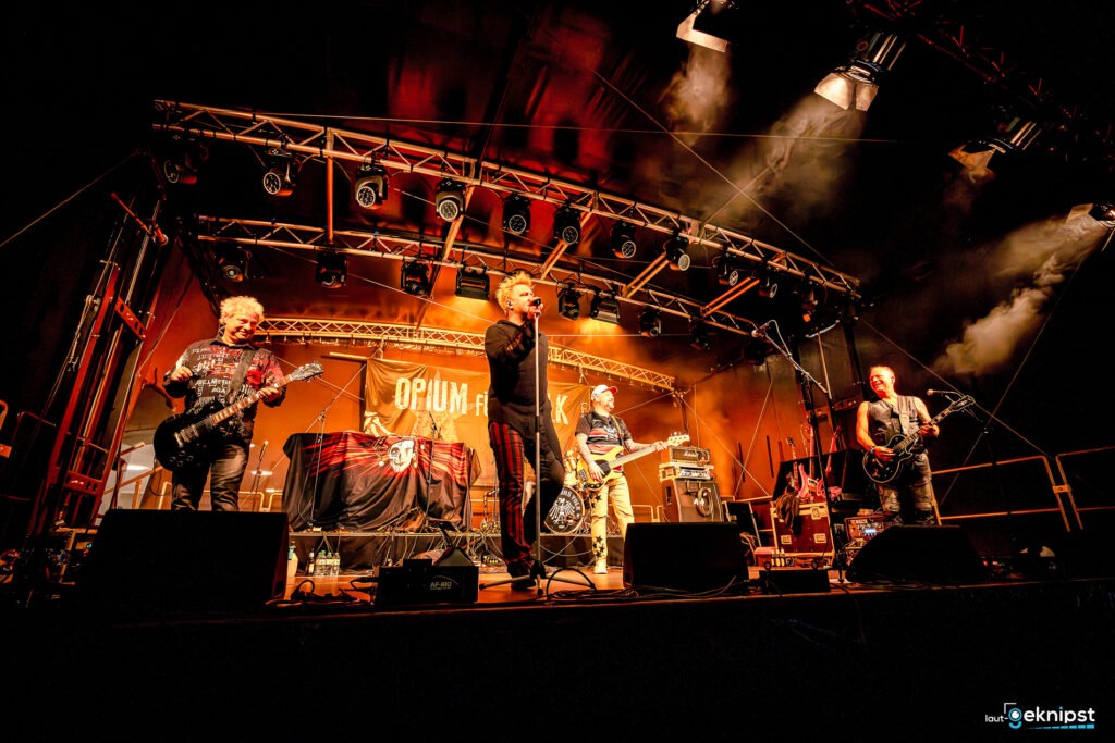 Band spielt auf einer Bühne mit Lichtern.