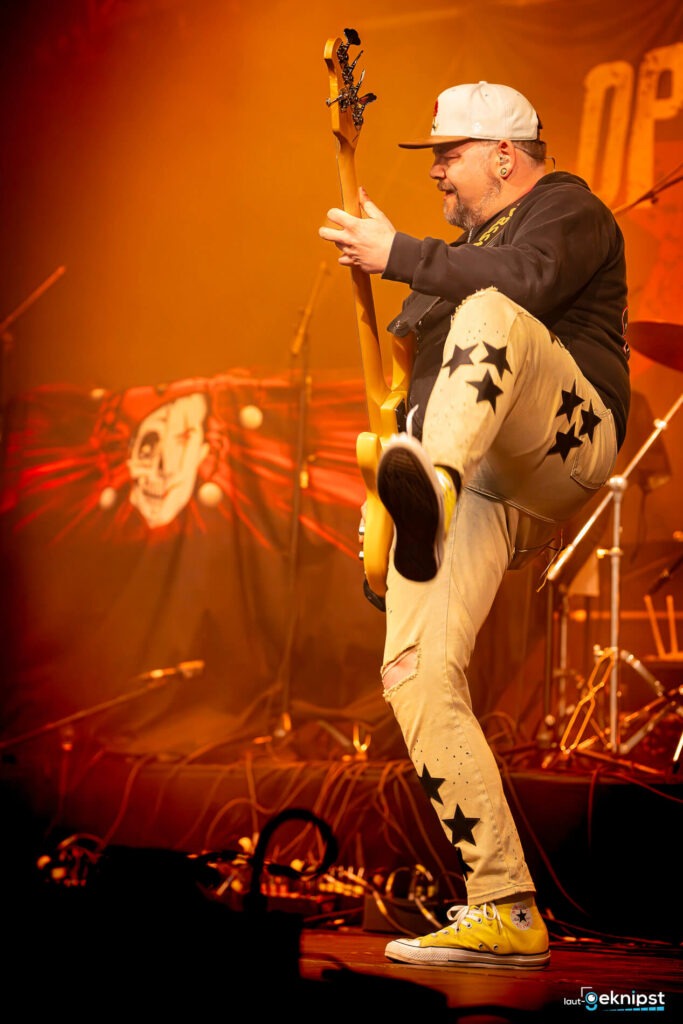 Bassist auf der Bühne mit gelben Schuhen und Sterne-Hose.