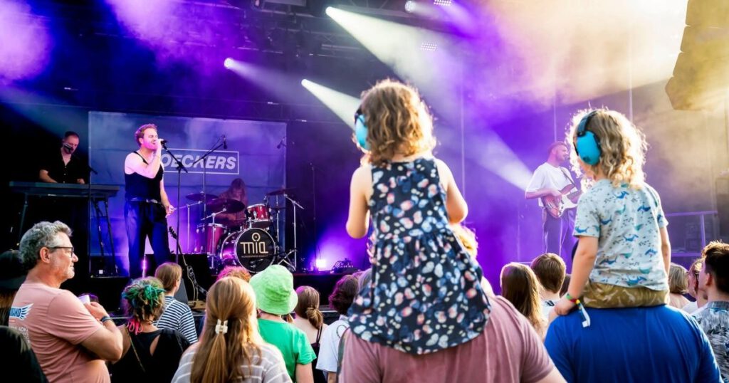 Kinder bei einem Konzert mit Kopfhörern.