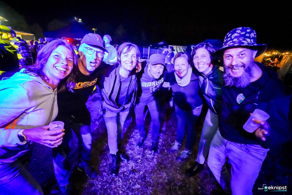 Lächelnde Gruppe bei Nacht im Freien zusammen.