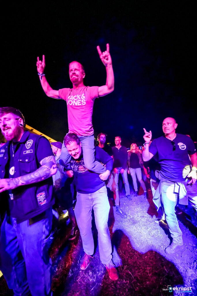 Festivalbesucher jubeln und feiern nachts.